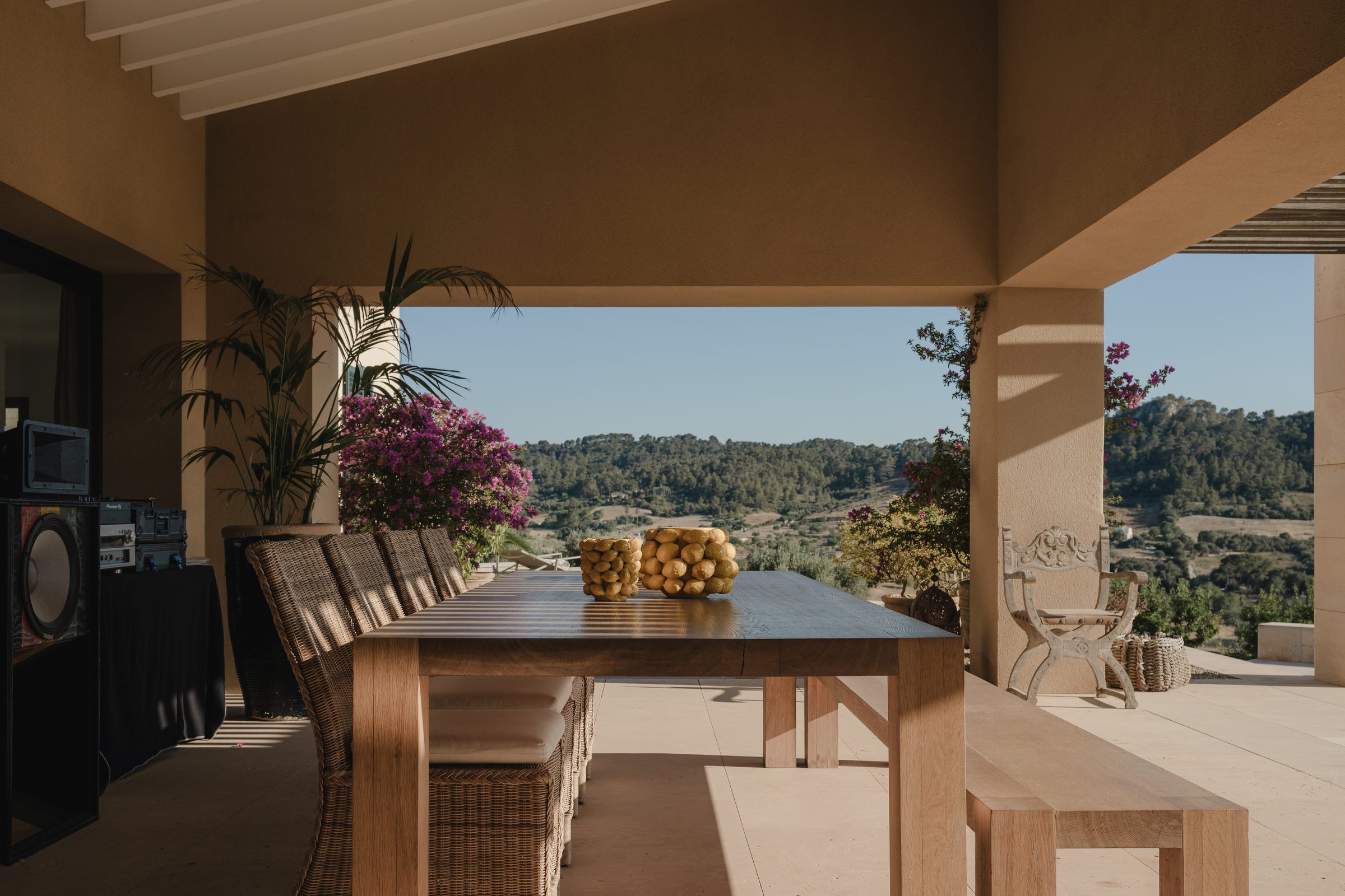 Überdachter Patio mit großem Esstisch und Blick in die Landschaft