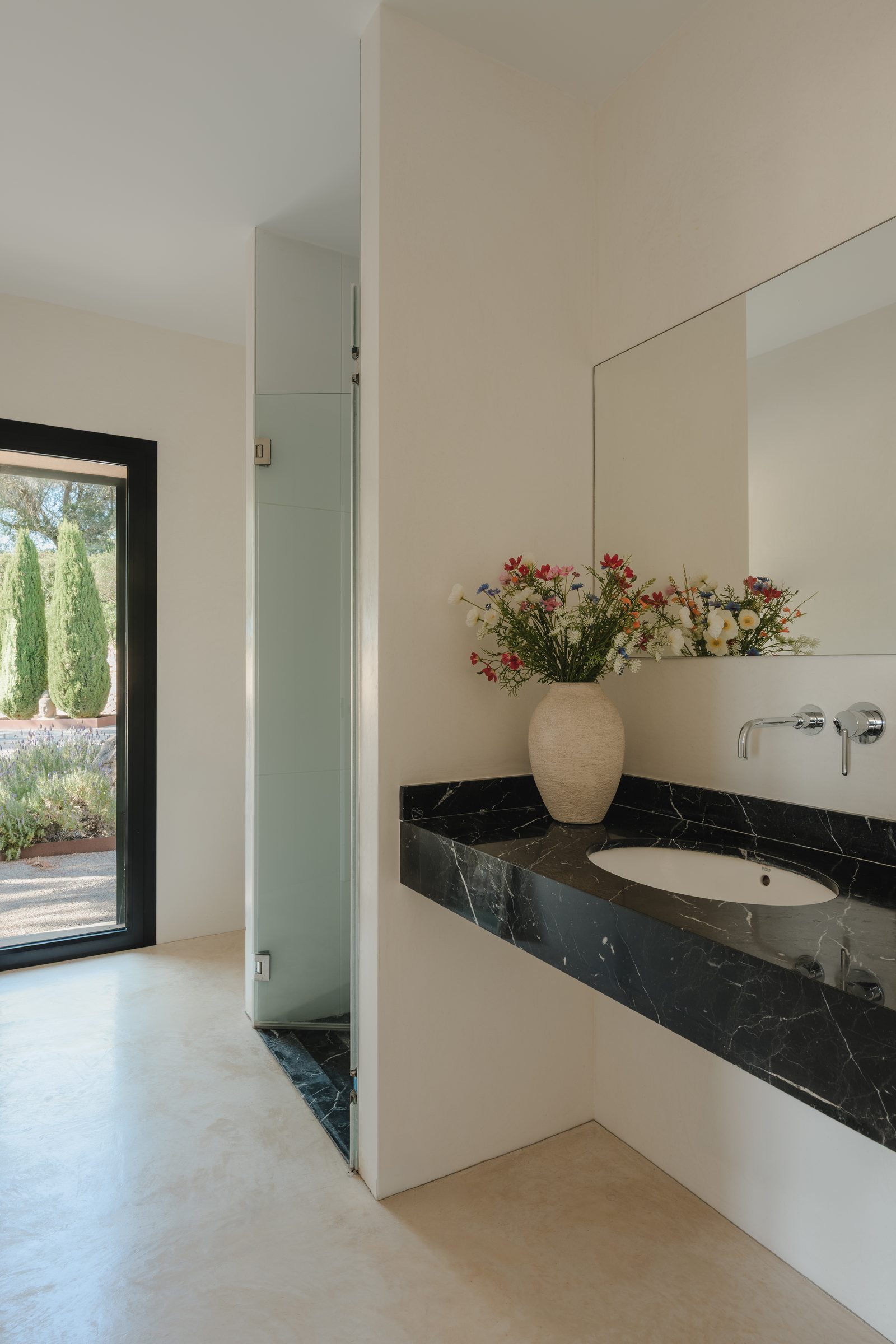 Badezimmer mit schwarzem Marmor-Waschtisch und Blick ins Freie